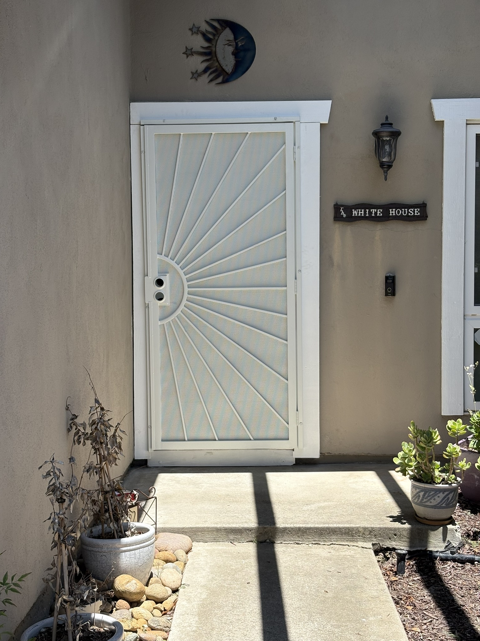 White security door with sunburst design and black hardware